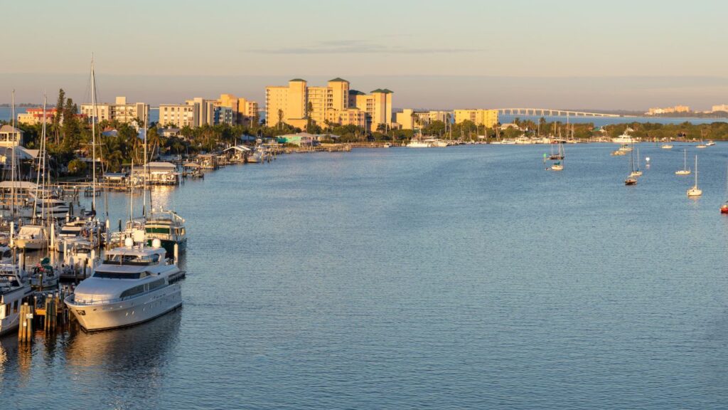 Fort Myers Beach waterfront skyline at sunrise with marina boats and buildings