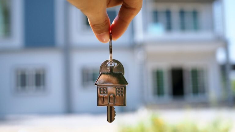 House key being handed over in front of a home, symbolizing successful Southwest Florida home selling with Worthington Realty