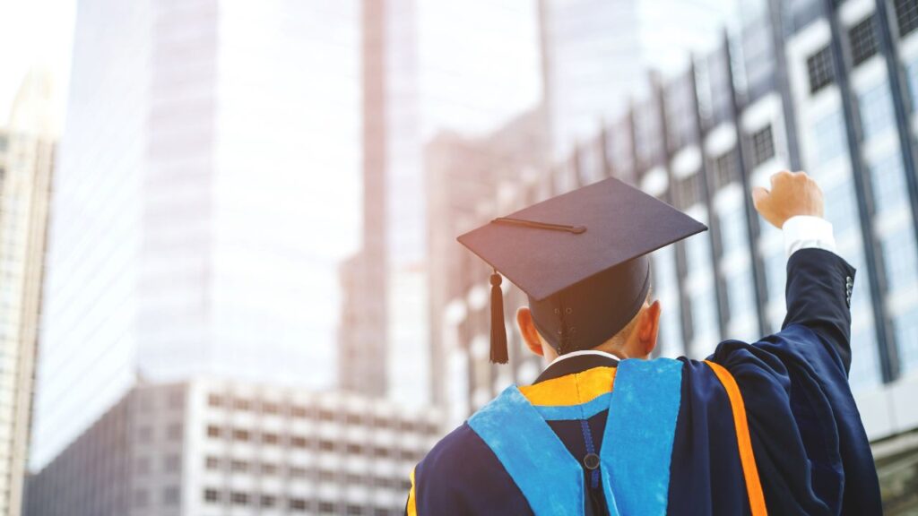 Graduate student celebrating achievement in front of city buildings in Southwest Florida