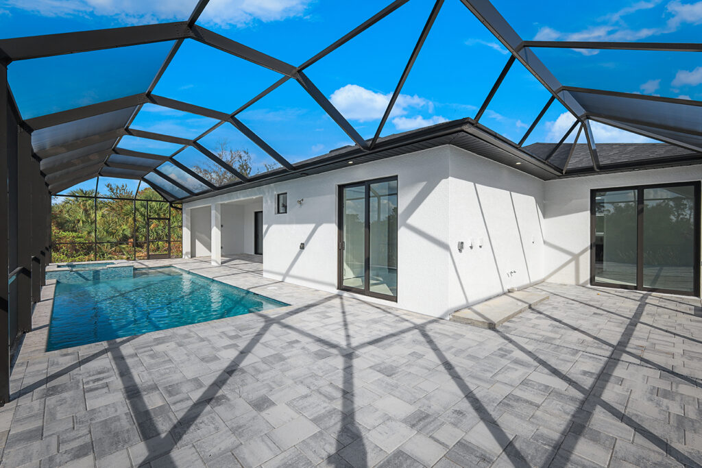 Screened-in lanai with a built-in summer kitchen, spacious patio, and optional pool upgrade in a new construction home in Cape Coral, FL.