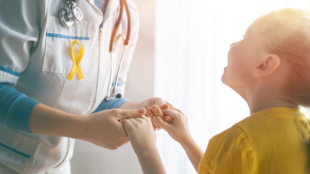 Doctor holding hands with a young cancer patient supported by Barbara’s Friends in Fort Myers
