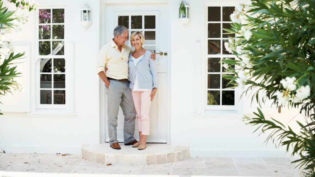 Smiling couple standing outside their new home purchased with cash in Fort Myers