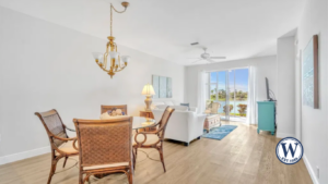 Bright and airy living and dining area in a Sutton Walk condo at Lexington Country Club, featuring luxury vinyl flooring and stunning lakefront views.