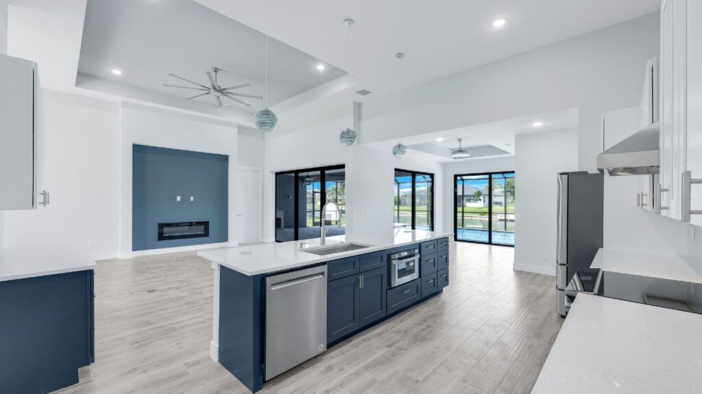 Alt Text Modern new-construction kitchen by Waterline Homes in Cape Coral with blue cabinets, quartz island, and canal-view sliders, from our guide to Cape Coral home builders.