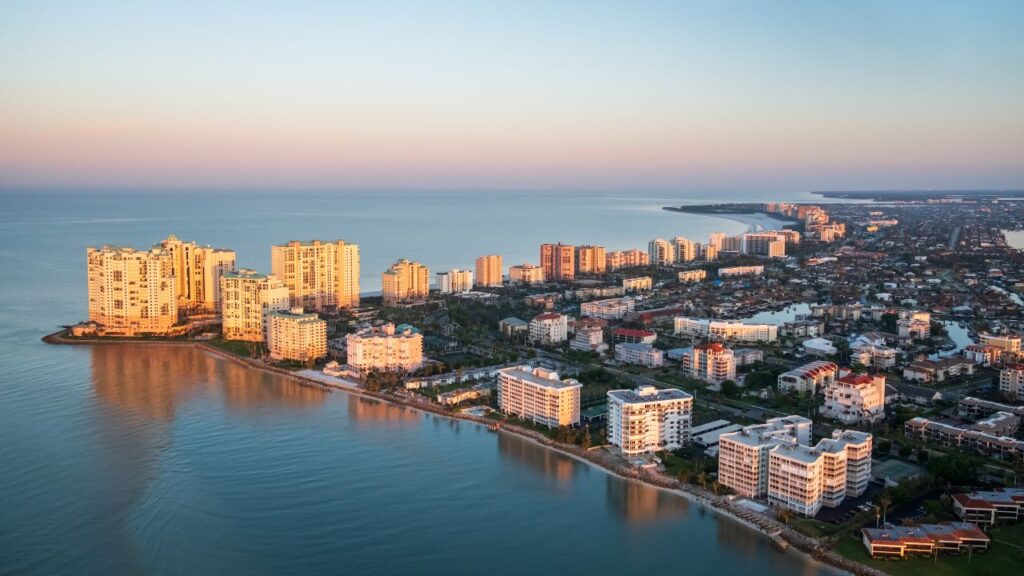 Aerial view of Florida Gulf Coast condos and beach at sunset, illustrating trends in the Florida housing market