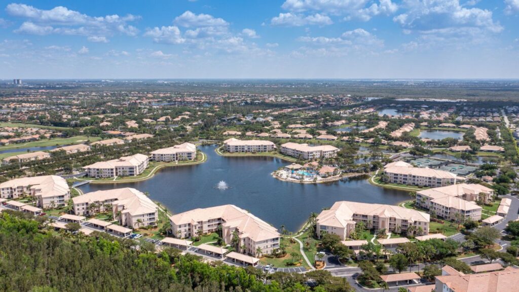 Aerial view of Southmont Cove condo buildings in Fort Myers surrounding a lake with resort-style amenities, ideal for investment