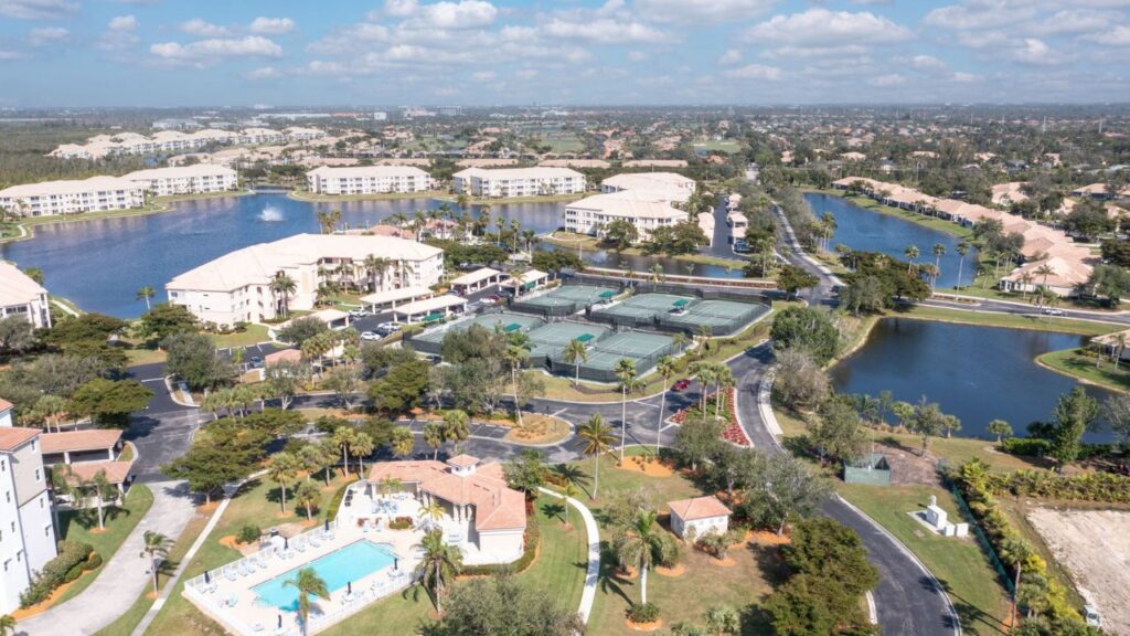 Aerial view of Southmont Cove Lexington condos in Fort Myers with lakefront buildings, tennis courts, and resort-style pool