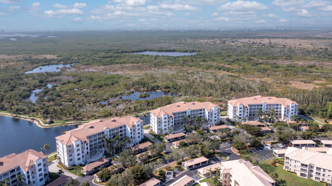 Aerial of Sutton Walk at Lexington Country Club in Fort Myers with preserve and lake views behind mid-rise condos.