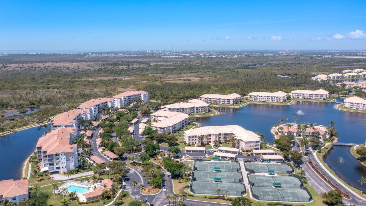 Aerial view of the Southmont Cove Amelia model condo in Fort Myers showing lakefront condos, covered parking, and resort-style amenities