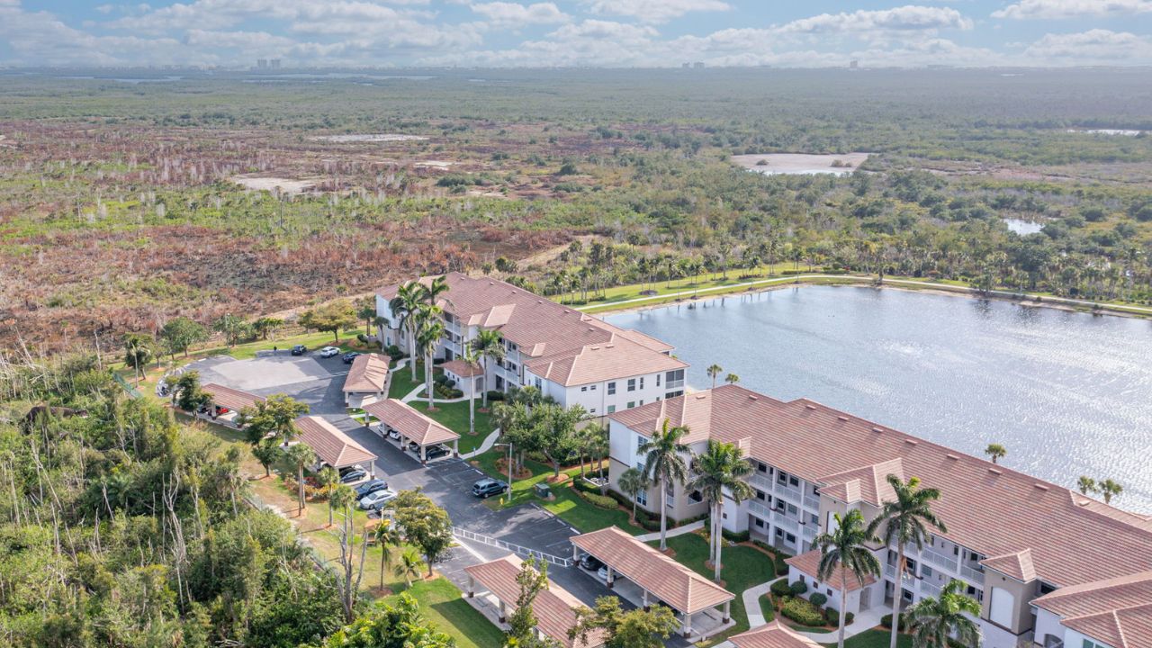 Aerial view of Sutton Walk condo buildings in Fort Myers overlooking the lake and surrounding nature preserve