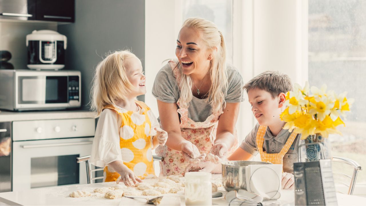 Mother baking with her two young children in a bright kitchen, celebrating Mother’s Day 2025 in Fort Myers