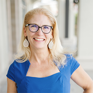 Ruth Haley, real estate expert and Sales Consultant at Worthington Realty, smiling in a blue dress