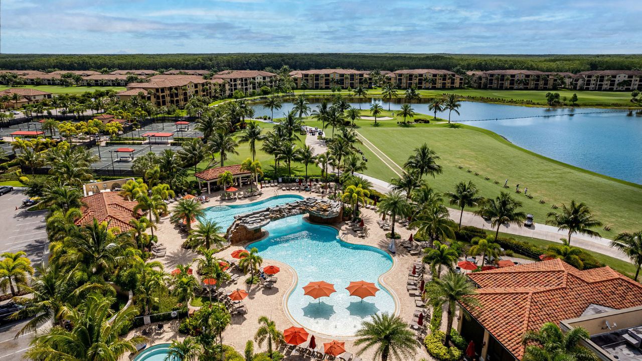 Aerial view of the resort-style pool, clubhouse, and golf course at Bonita National Golf & Country Club