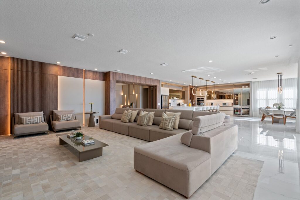 Modern open-concept living room and kitchen with custom lighting, soft neutrals, and luxury finishes in Southwest Florida.