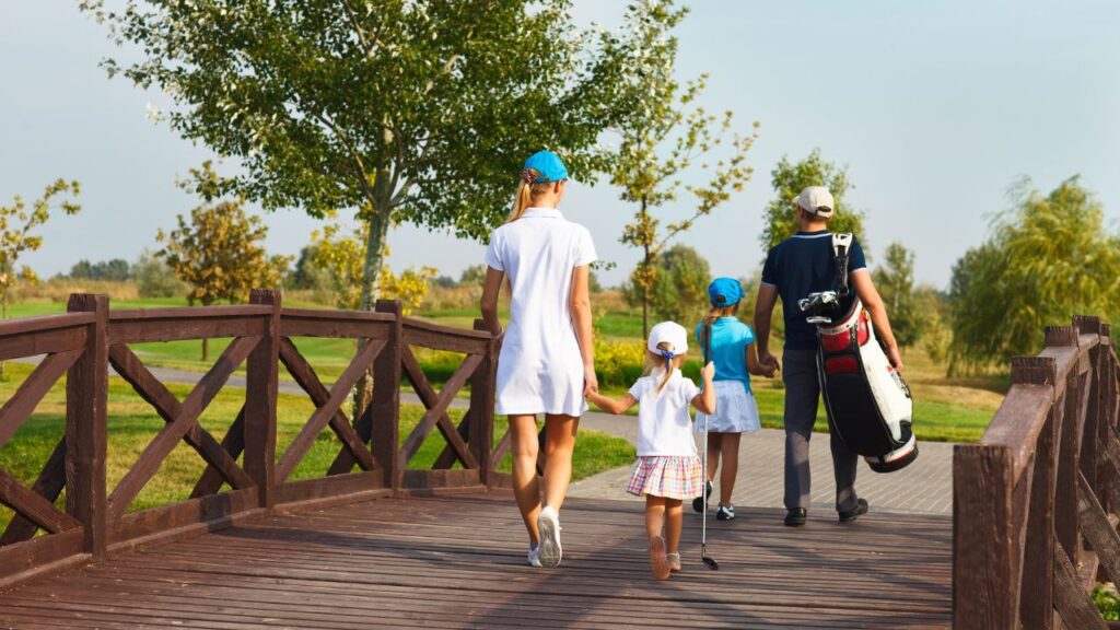Family walking together on a wooden bridge at a golf course in Estero, symbolizing the Estero Real Estate market update