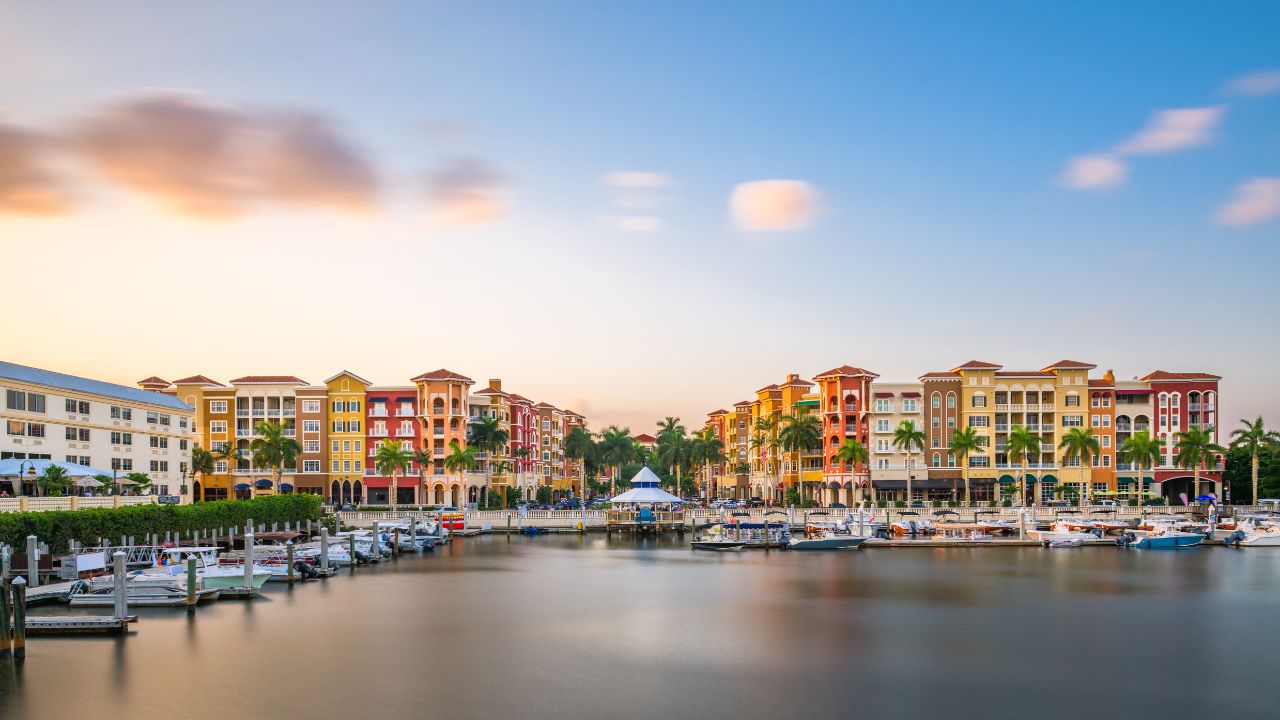Waterfront condos and colorful buildings at the Naples marina during sunset, representing the September 2025 Naples market update