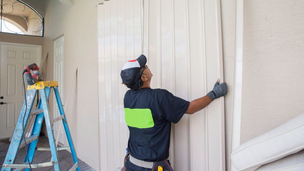 Contractor installing storm panels on a Southwest Florida house before hurricane season
