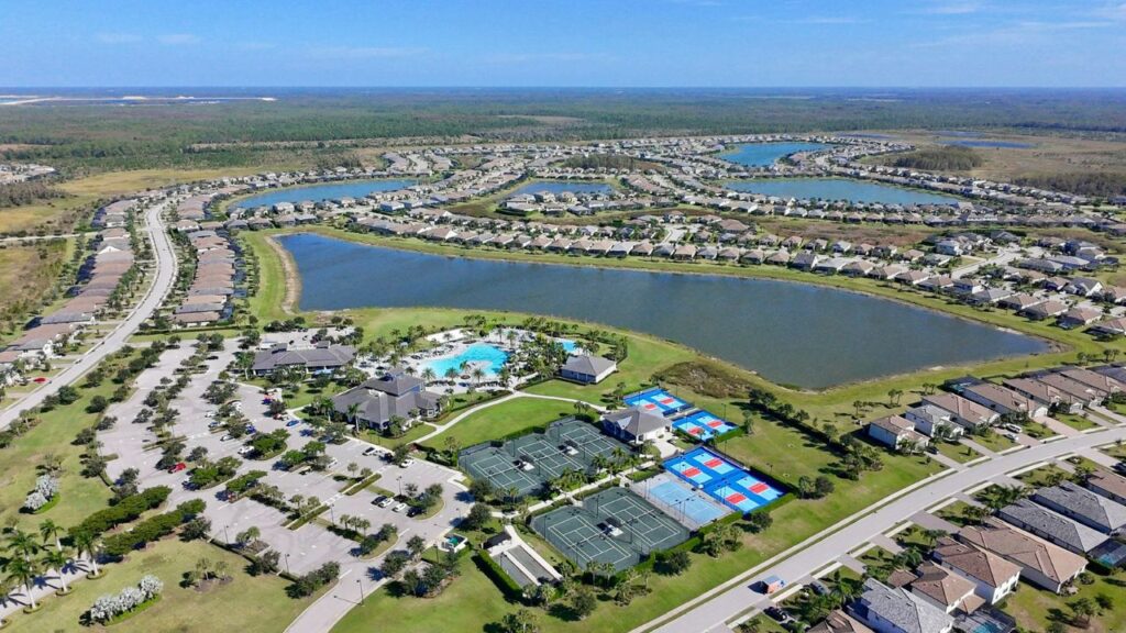 Aerial view of The Place at Corkscrew in Estero Florida showing lakes, tennis courts, pool, and surrounding homes