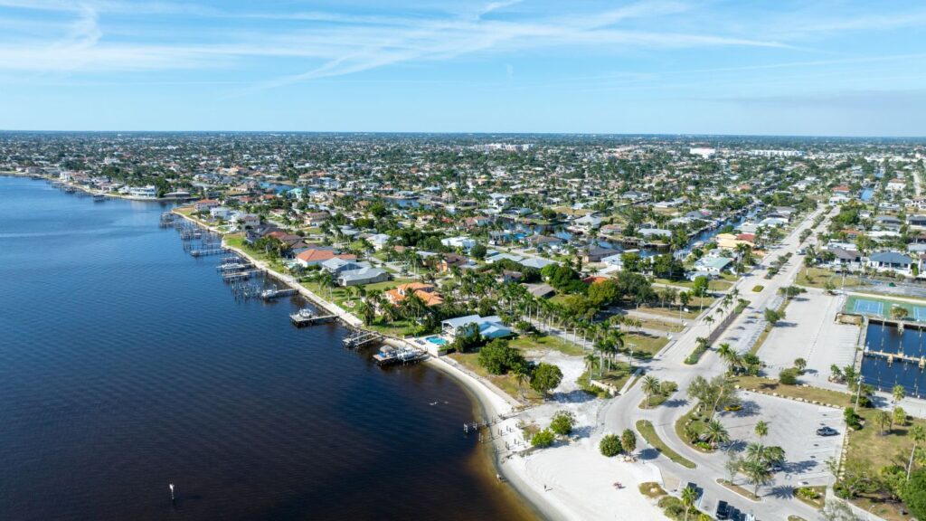 Aerial view of the Cape Coral Yacht Club area with waterfront homes, beach access, and canals.