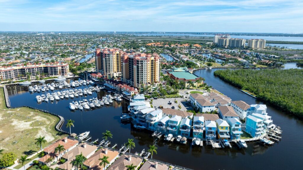 Aerial view of Cape Harbour in Cape Coral with high-rise condos, marina, and surrounding homes.