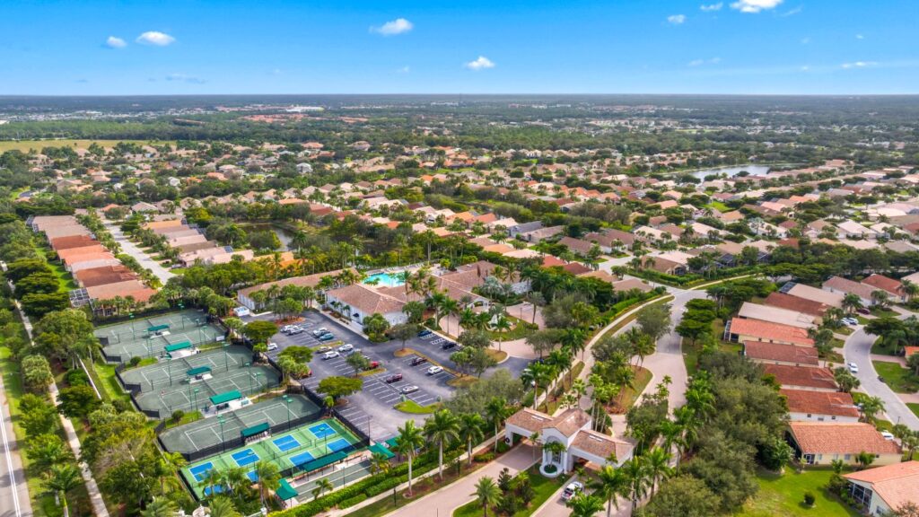 Aerial view of the Cascades at Estero showing the clubhouse, pool, tennis courts, and surrounding homes.