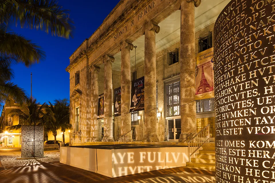 Sidney & Berne Davis Art Center at night in downtown Fort Myers, FL, with illuminated sculpture casting patterns on the historic facade