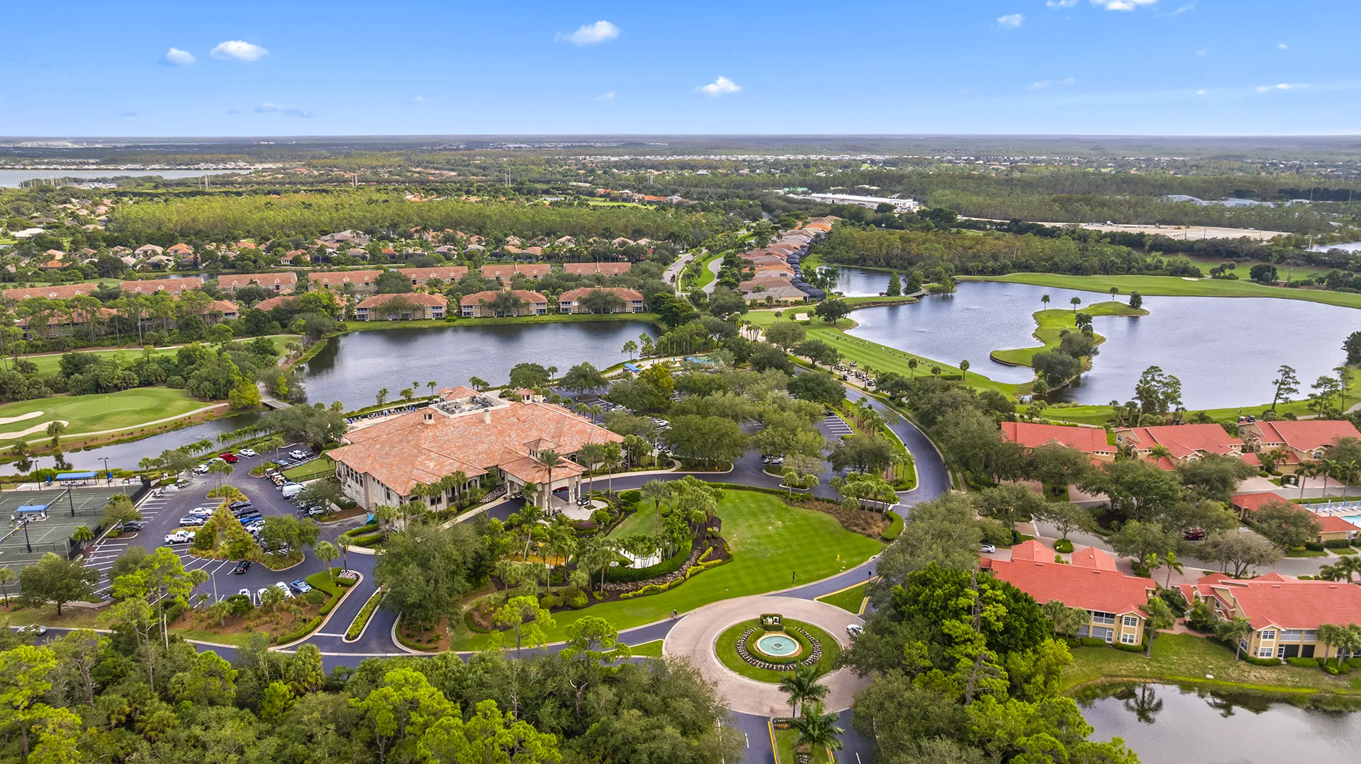 Aerial view of Grandezza Golf & Country Club in Estero, FL, featuring the 53,000-square-foot clubhouse, resort-style pool, tennis courts, 18-hole championship golf course, lakes, and luxury homes for sale.