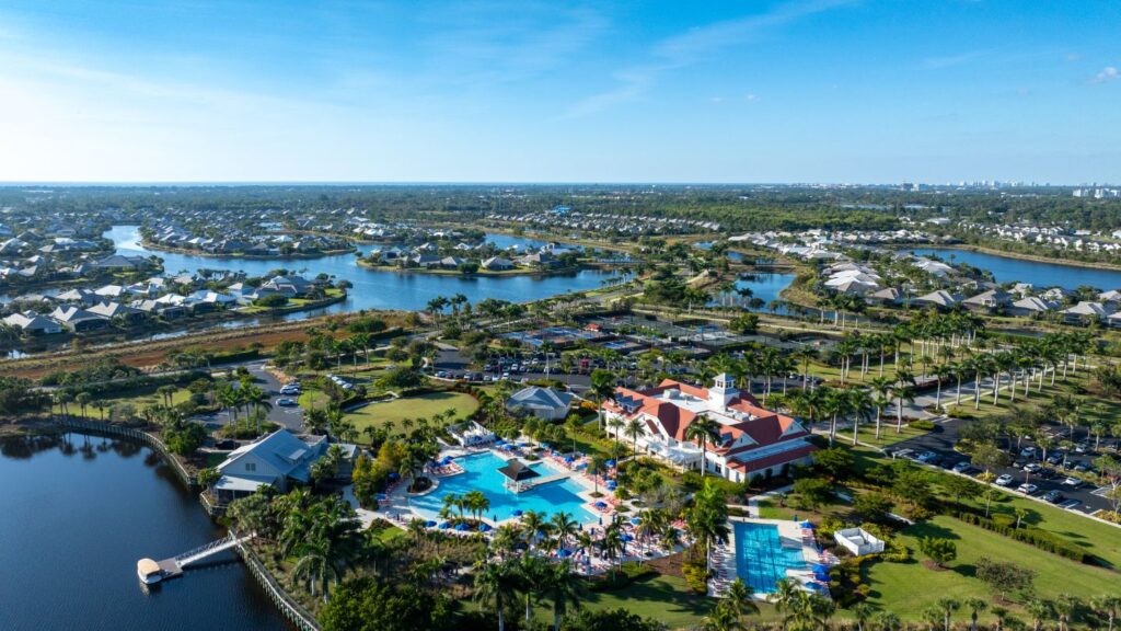 Aerial view of Isles of Collier Preserve in Naples with lakes, homes, clubhouse, and resort-style pool.