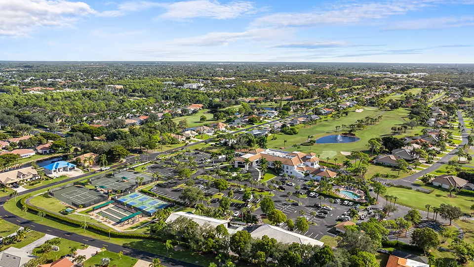 Aerial view of the clubhouse, resort-style pool, tennis courts, and pickleball courts at Spanish Wells Golf & Country Club, a gated community with homes for sale in Bonita Springs, FL