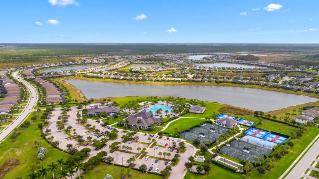 Aerial view of The Place at Corkscrew in Estero showing the clubhouse, pools, tennis courts, and surrounding homes.