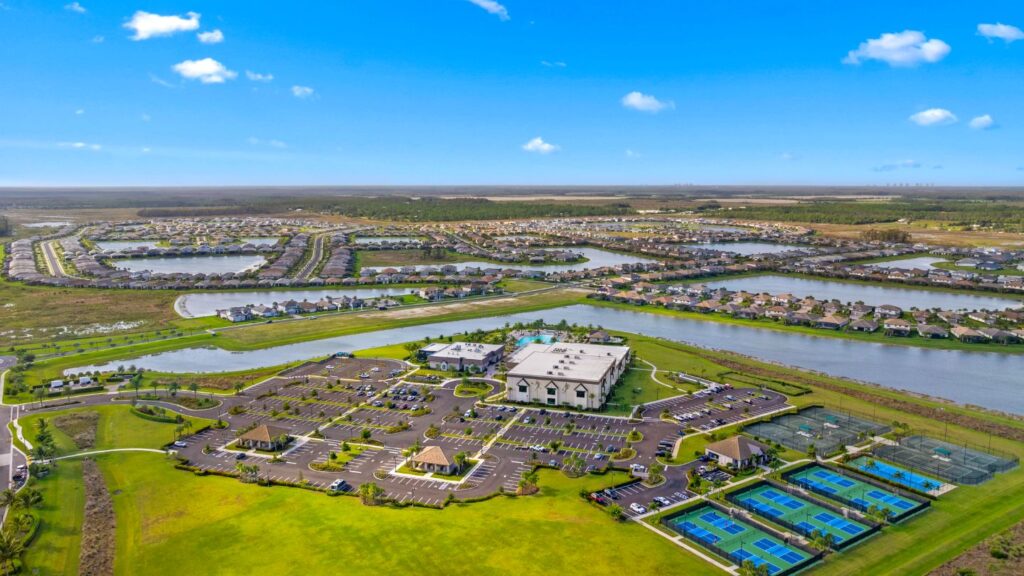 Aerial view of Verdana Village in Estero, Florida including the amenity center, sports courts, lakes, and neighborhoods.