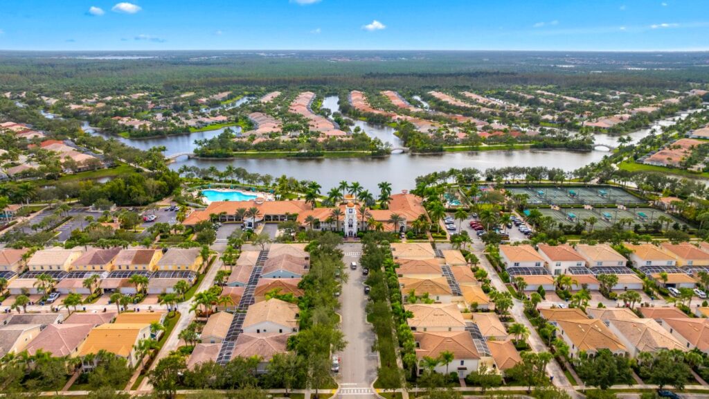 Aerial view of Village Walk in Bonita Springs showing lakefront homes, bridges, clubhouse, and community layout.
