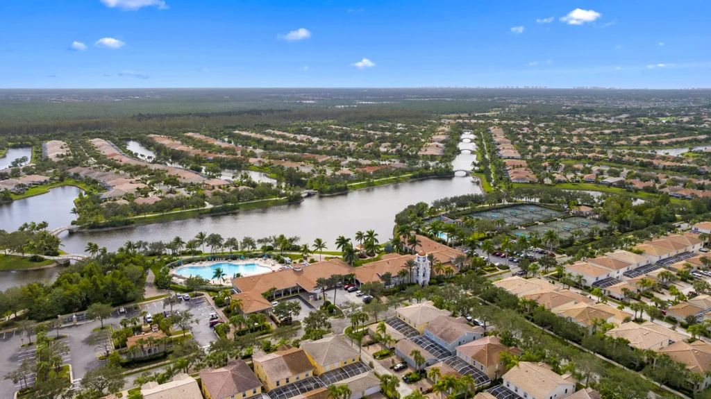 Aerial view of Village Walk of Bonita Springs, a gated community with homes for sale featuring scenic lakes, Venetian-style bridges, and walkable neighborhoods in Bonita Springs, FL