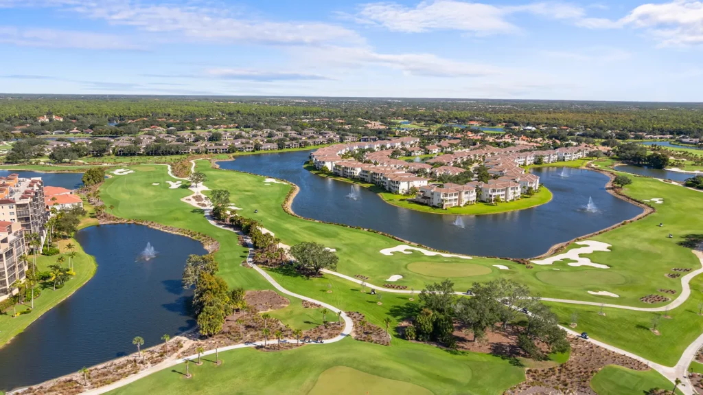 Aerial view of The Vineyards in North Naples, FL, a gated golf community with homes for sale featuring the championship golf course, clubhouse, pool, and tennis courts
