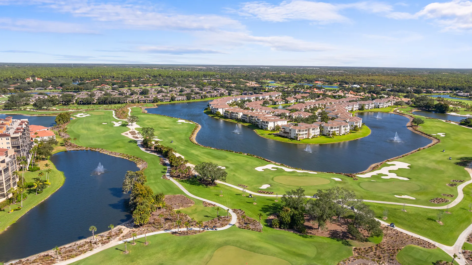 Aerial view of The Vineyards in North Naples, FL, a gated golf community with homes for sale featuring the championship golf course, clubhouse, pool, and tennis courts