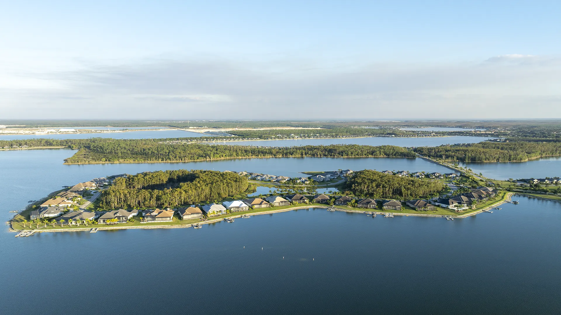 Aerial view of WildBlue in Fort Myers, FL, showcasing expansive lakes, lakefront homes with private docks, boating access, resort amenities, and homes for sale.