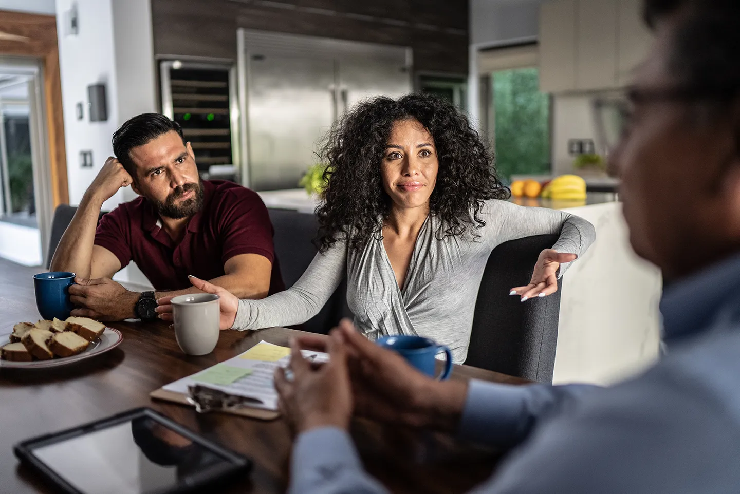 Homeowners meeting with a real estate agent during an in-home listing consultation discussing home selling decisions