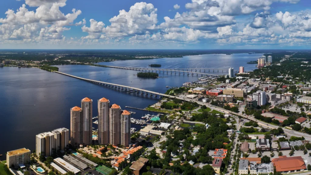 Aerial view of downtown Fort Myers and Caloosahatchee River showing bridges, waterfront condos, and city neighborhoods.