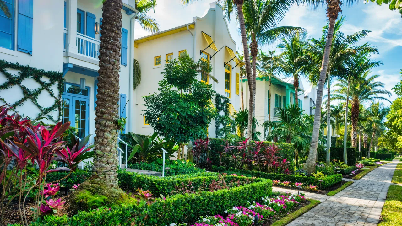 Colorful Naples Florida homes with tropical landscaping along a manicured residential streetscape.