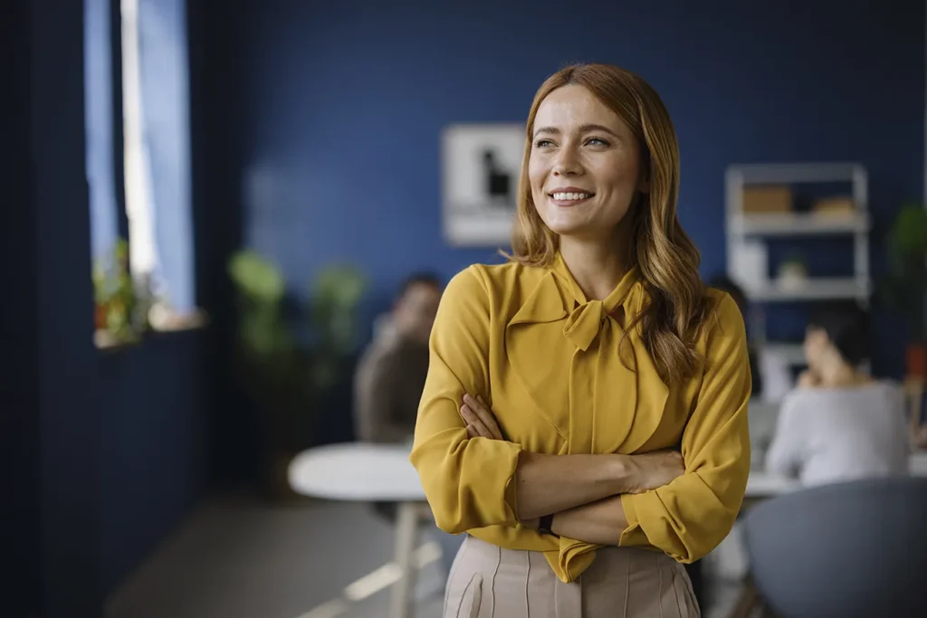 Confident real estate professional standing with arms crossed, representing the deeper meaning of professionalism in real estate