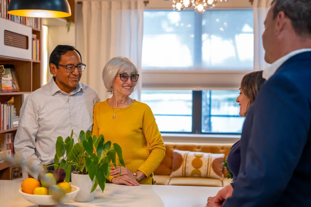 Worthington Realty agents having a relaxed conversation with clients in their Southwest Florida home