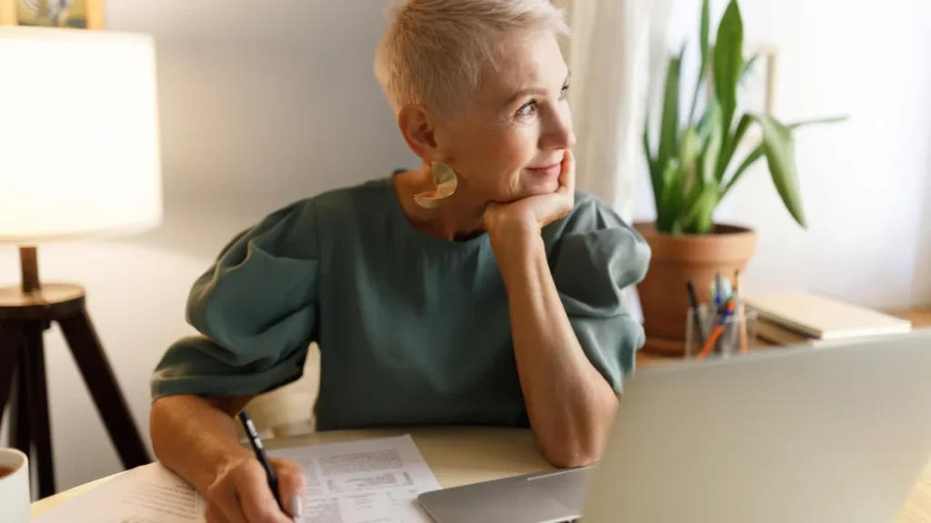 Real estate agent pausing to reflect at her desk—understanding why real estate agents fail starts with recognizing the gap between expectations and reality