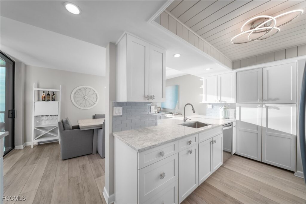 Renovated kitchen with white shaker cabinets and quartz countertops in Naples Gulf-front condo at Bayshores