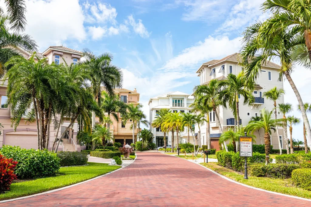 Multi-story coastal homes along a brick-paved private road in Bonita Springs