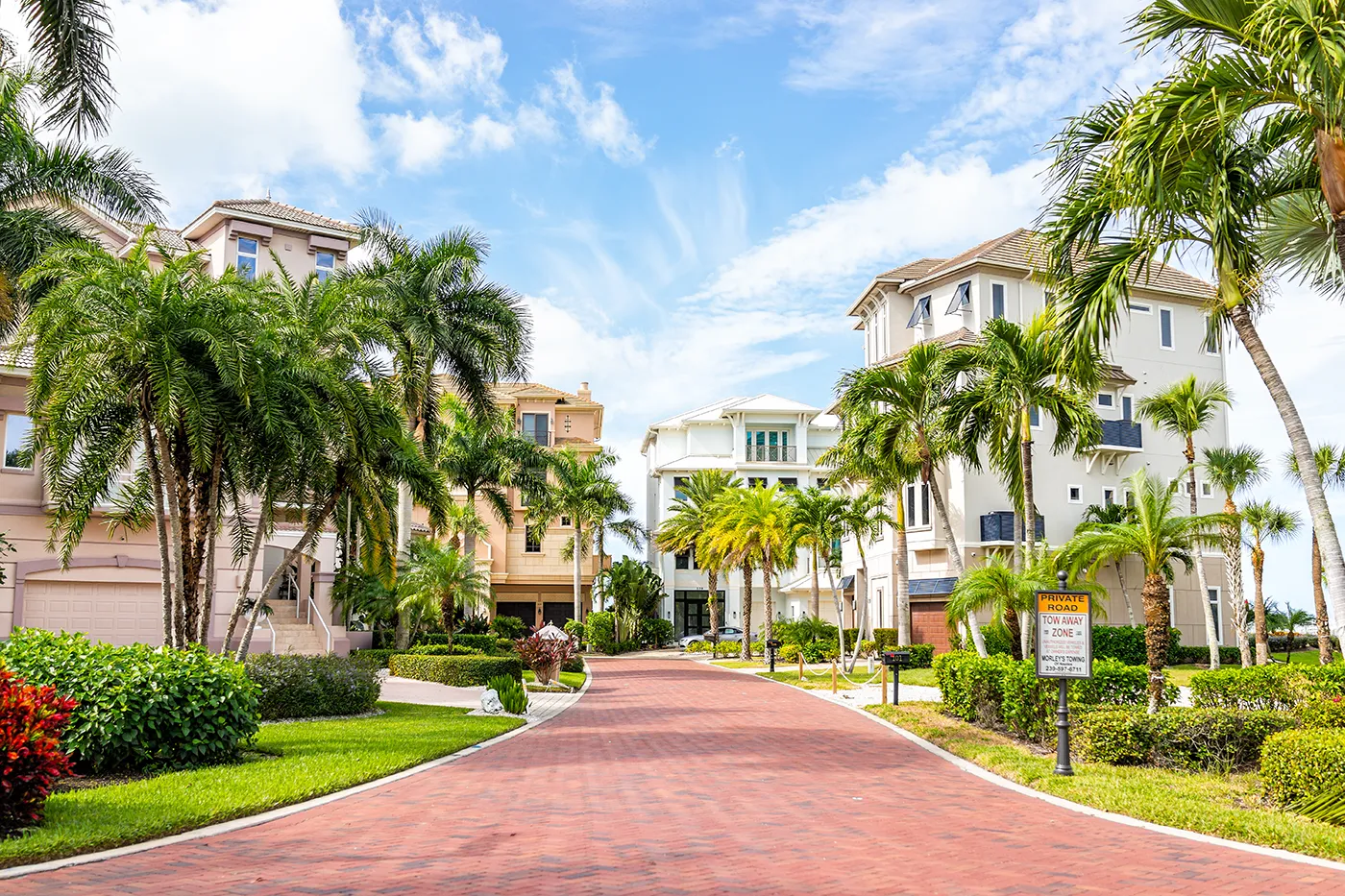 Multi-story coastal homes along a brick-paved private road in Bonita Springs