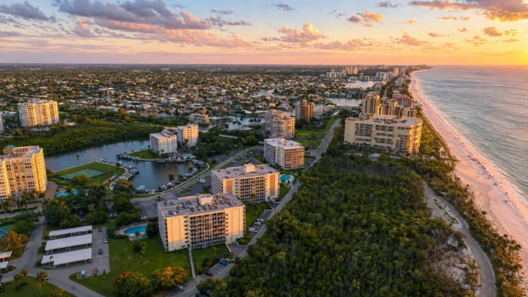 Aerial sunset view of Baker-Carroll Point condos on the Bluebill Avenue peninsula at the north end of Vanderbilt Beach in Naples.