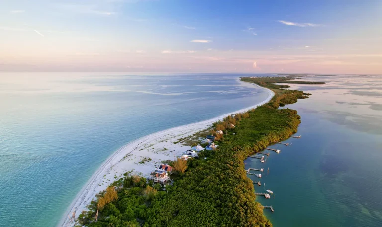 Aerial sunset view of North Captiva Island showing private docks and beachfront homes along the Gulf.