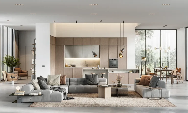 Bright open-plan living room and kitchen with gray sectional sofas, wood cabinetry, and floor-to-ceiling windows