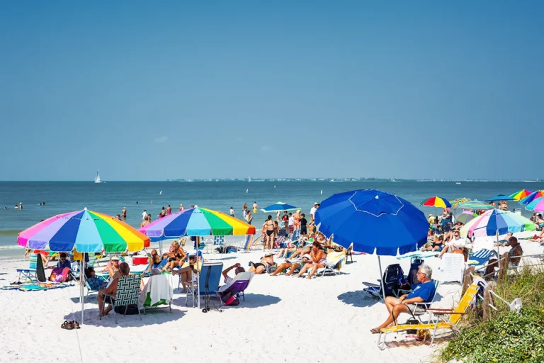 Southwest Florida summer beach conditions in 2026 with families enjoying clear Gulf water and colorful umbrellas on a sunny beach
